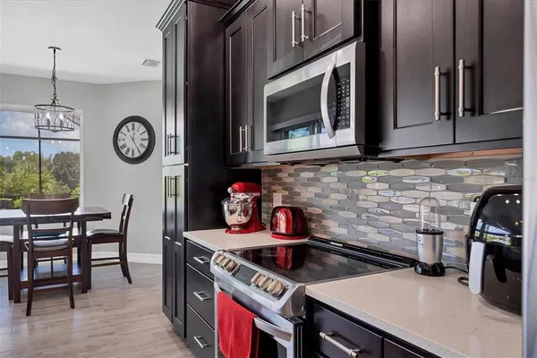 a kitchen with a stove and a wooden floor