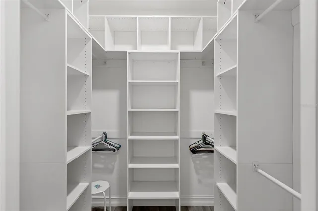 a view of walk in closet with empty racks
