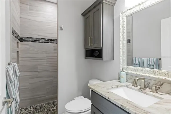 a bathroom with a granite countertop sink toilet and shower