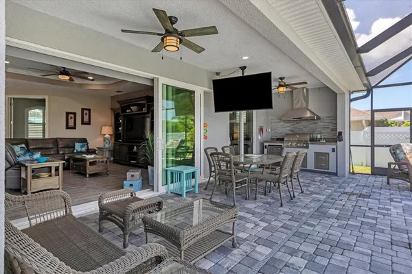 a living room with patio furniture and a flat screen tv