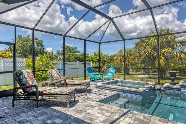 a living room with patio furniture and a potted plant