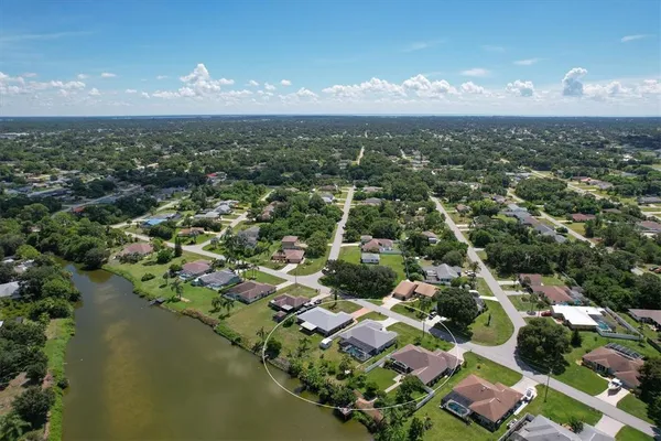 an aerial view of residential houses with outdoor space and lake view