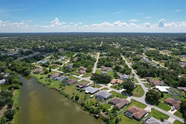 an aerial view of residential houses with outdoor space and lake view