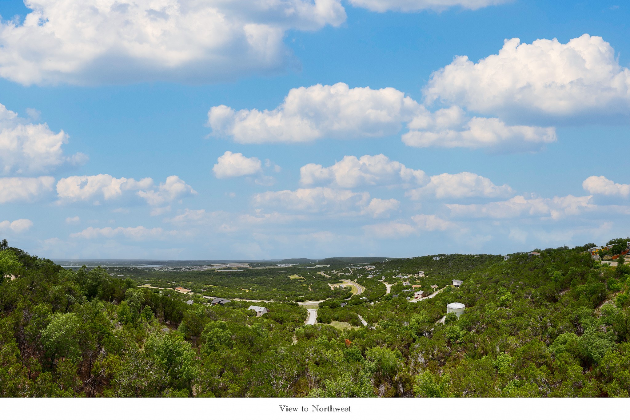 8220 Bar K Ranch Road Lago Vista, TX 78645 - Photo 6 of 8 A sweeping aerial view showcases the serene rural landscape with scattered homes and verdant trees under a bright sky.