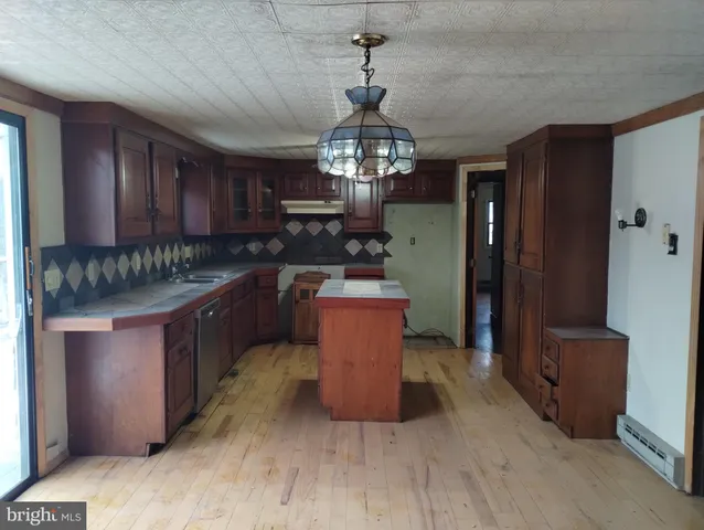 a kitchen with stainless steel appliances granite countertop wooden cabinets and sink