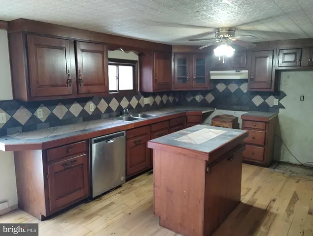 a kitchen with a stove a sink a center island and cabinets