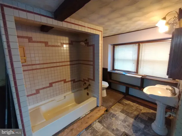 a bathroom with a tub sink and mirror