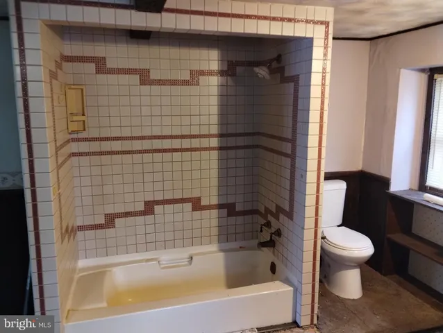 a white toilet sitting next to a white cabinet