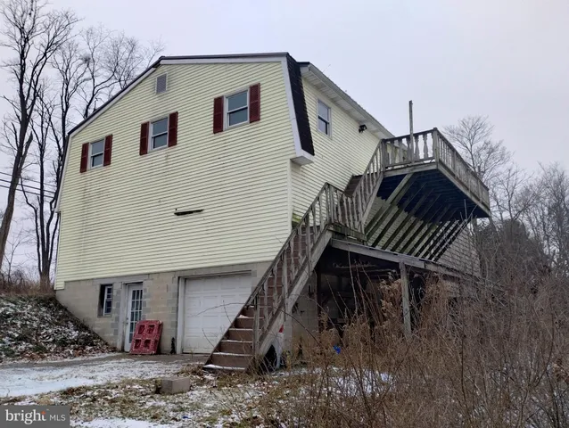 a view of a house with backyard and deck