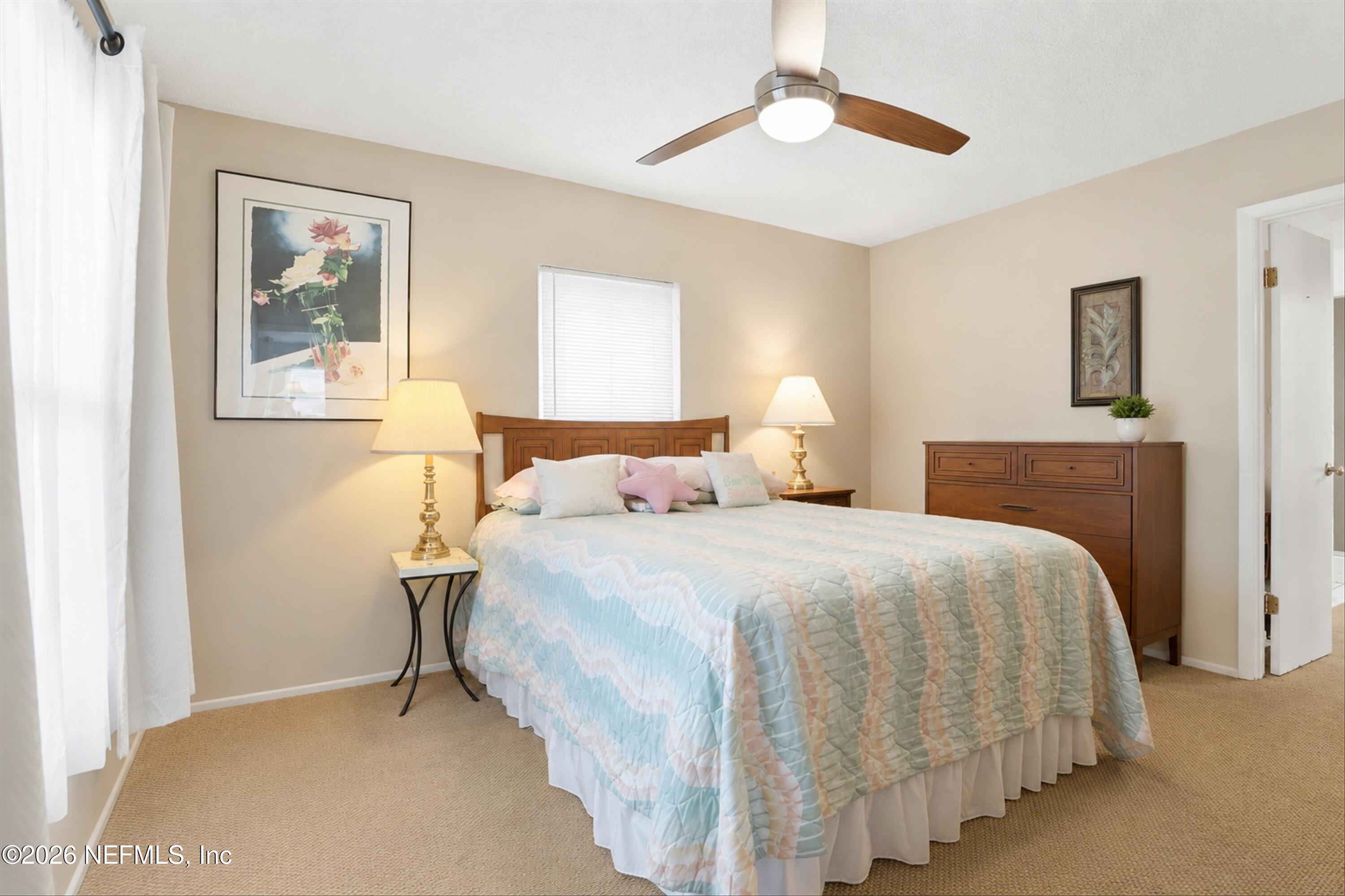 124 Hopkins Street Neptune Beach, FL 32266 - Photo 23 of 44 a bedroom with bed and paintings on the wall