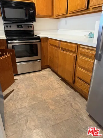 a kitchen with wooden cabinets and a stove top oven