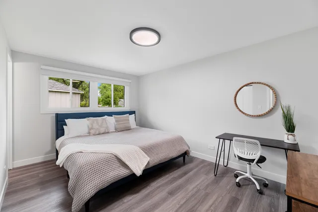 a bedroom with a bed and wooden floor