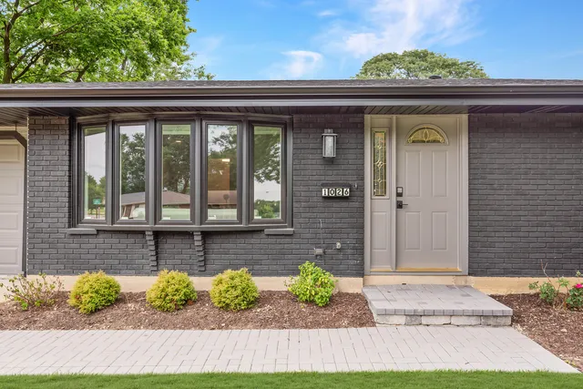 a front view of a house with a yard and outdoor seating