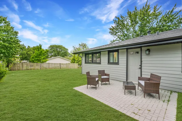 a view of a house with a backyard and sitting area