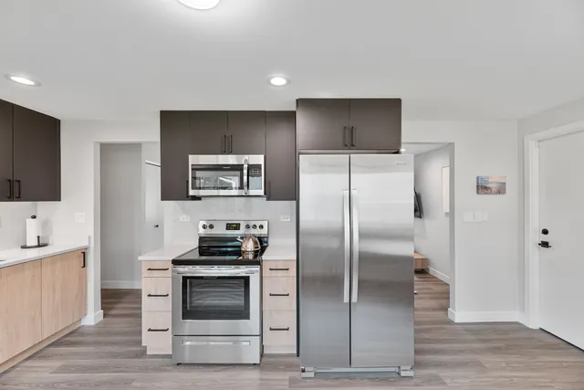 a kitchen with granite countertop a refrigerator and a stove top oven