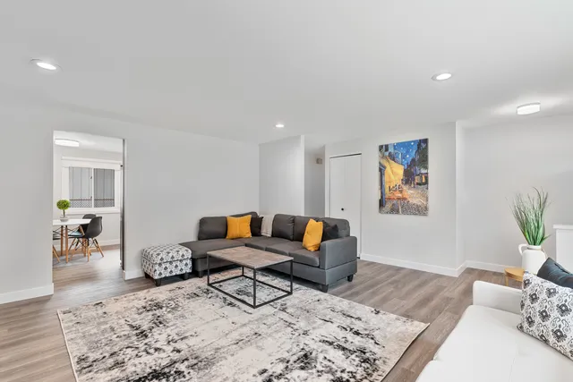 a living room with furniture and wooden floor