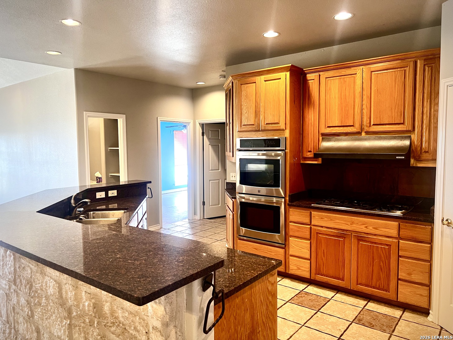 1816 Shepherds Bulverde, TX 78163 - Photo 13 of 32 a kitchen with stainless steel appliances kitchen island granite countertop a refrigerator a stove and a sink with granite countertops