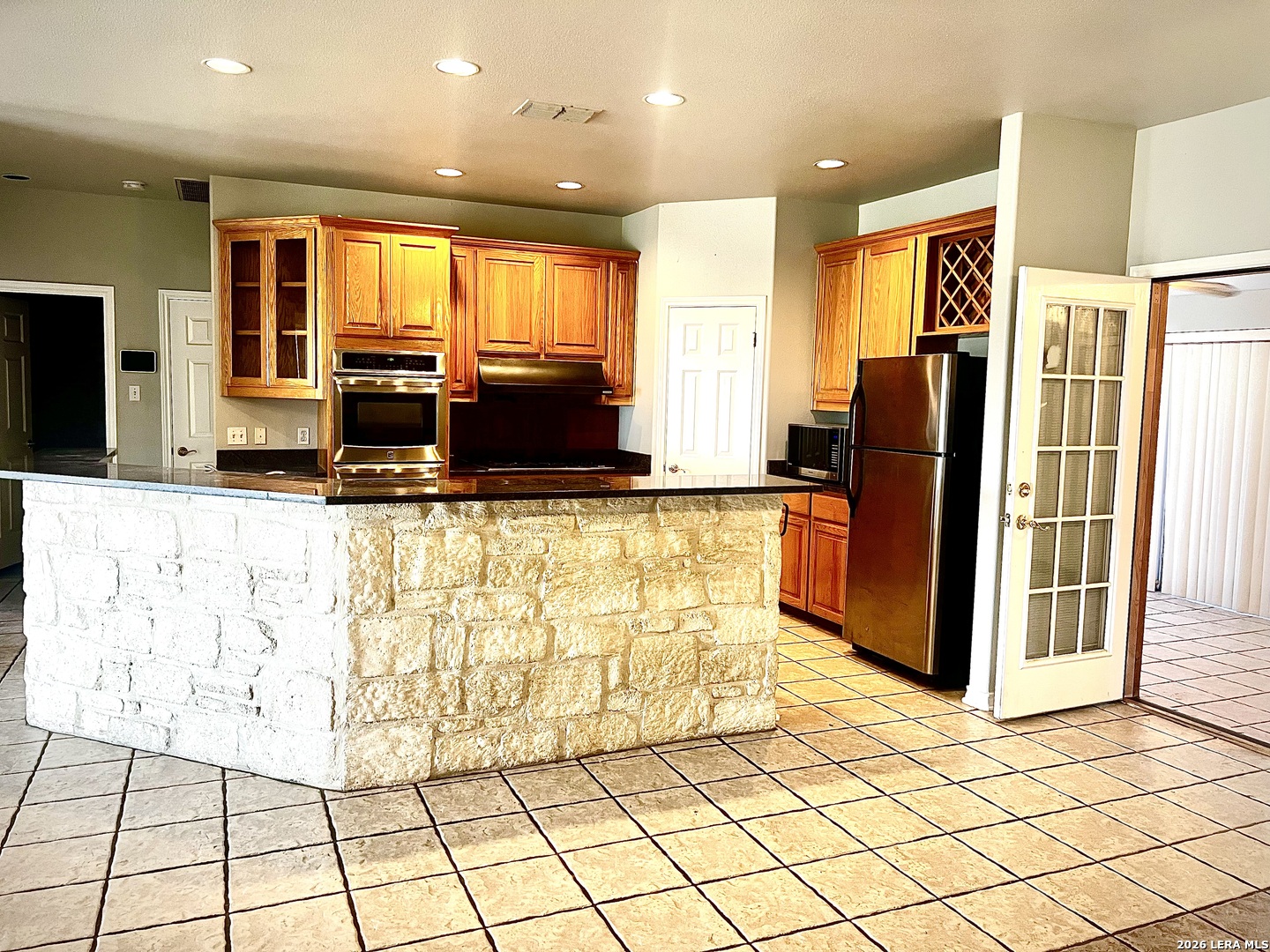 1816 Shepherds Bulverde, TX 78163 - Photo 4 of 32 a kitchen with stainless steel appliances kitchen island granite countertop a refrigerator and a stove top oven
