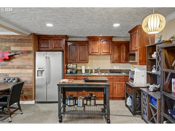 a kitchen with stainless steel appliances granite countertop a refrigerator and a stove top oven