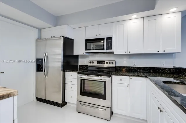 a kitchen with cabinets stainless steel appliances and a counter space