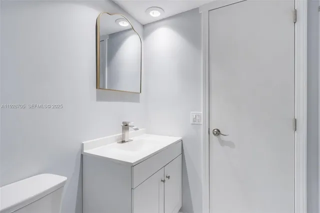 a bathroom with a sink mirror and toilet