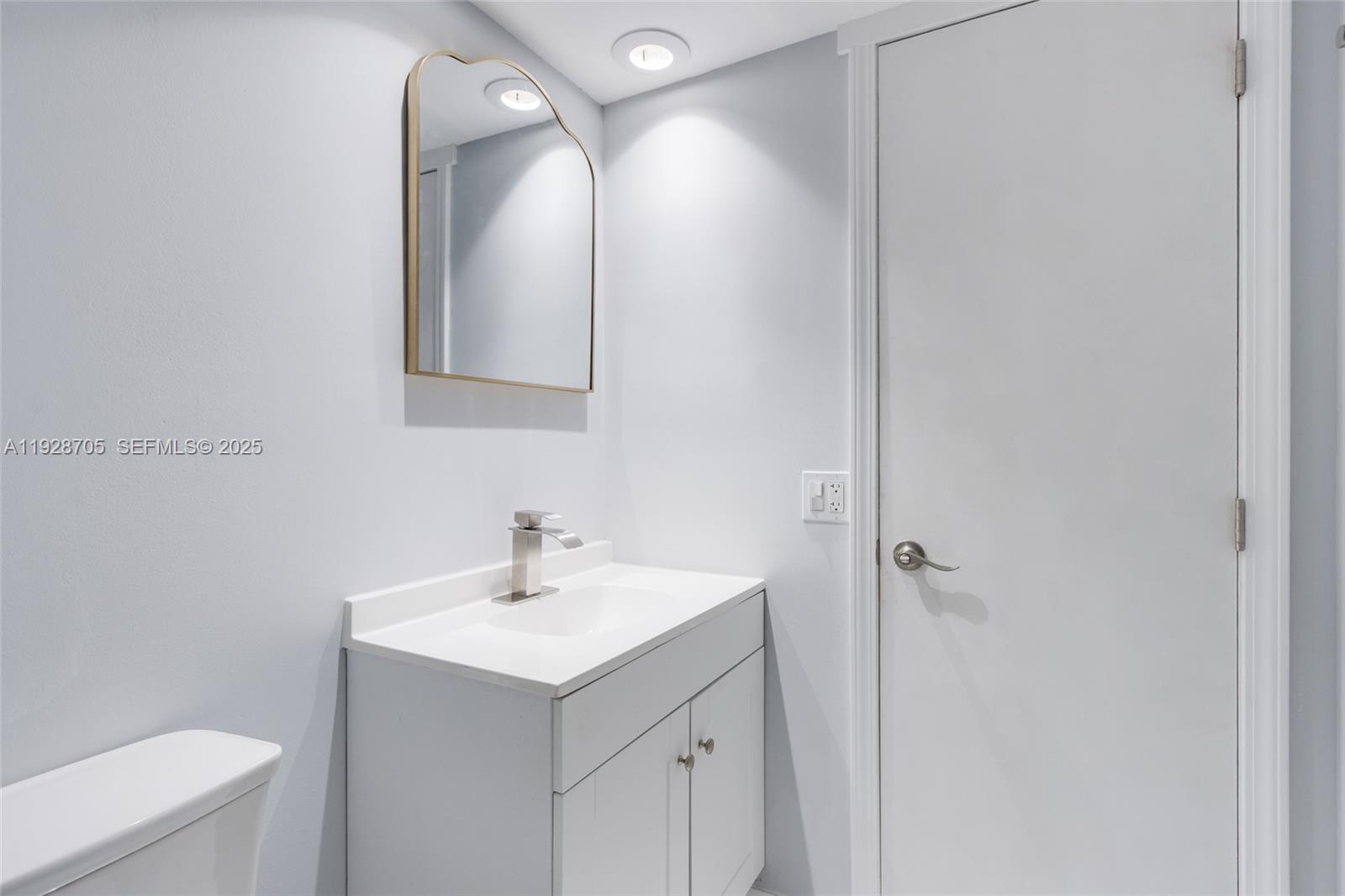 3090 North Course Drive, Unit 609 Pompano Beach, FL 33069 - Photo 28 of 36 a bathroom with a sink mirror and toilet
