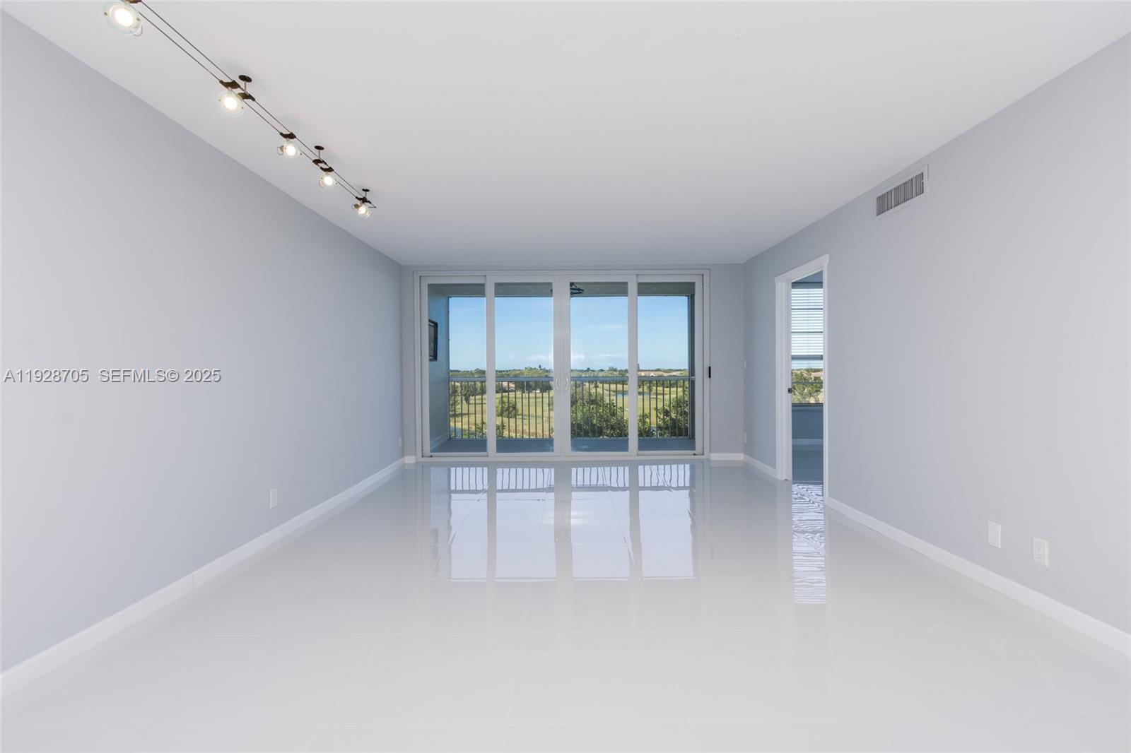 3090 North Course Drive, Unit 609 Pompano Beach, FL 33069 - Photo 4 of 36 a view of an empty room with a sliding door