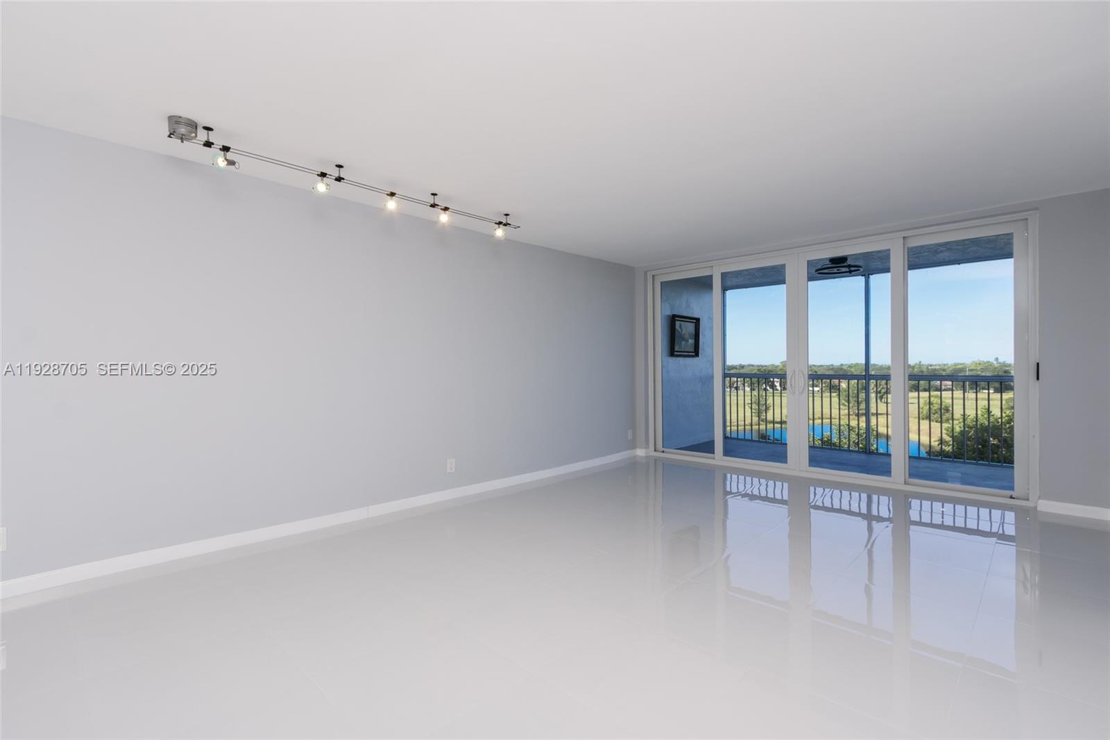 3090 North Course Drive, Unit 609 Pompano Beach, FL 33069 - Photo 5 of 36 wooden floor in an empty room with a window