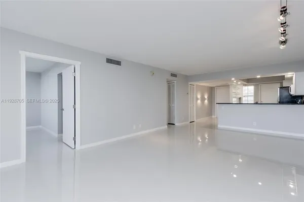 a view of a big room with wooden floor and windows