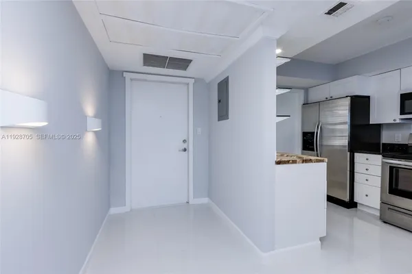 a kitchen with a refrigerator and a stove top oven