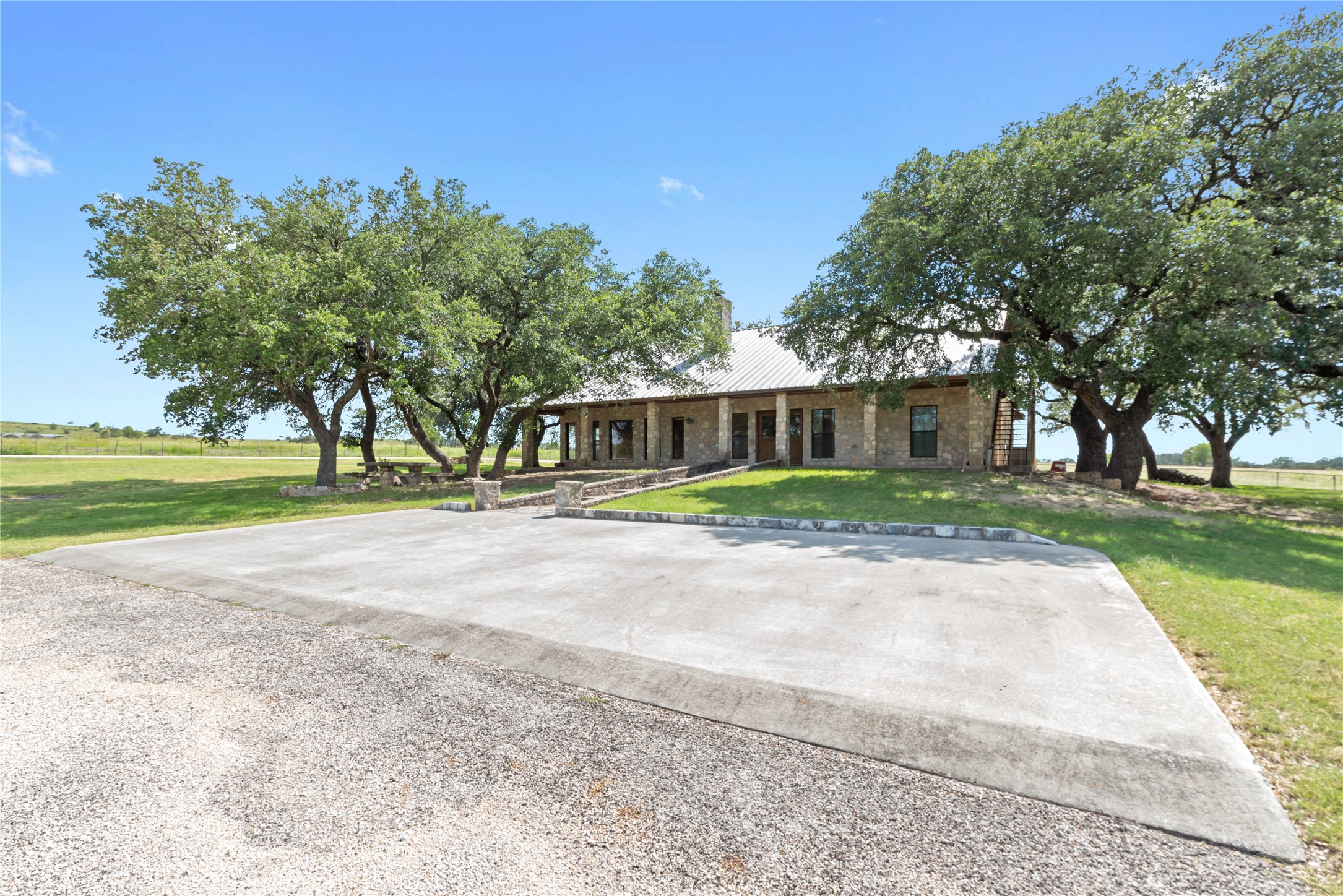 125 Hye Albert Road Hye, TX 78635 - Photo 15 of 39 Ranch-style house with a front yard, stone siding, covered porch, and a metal roof