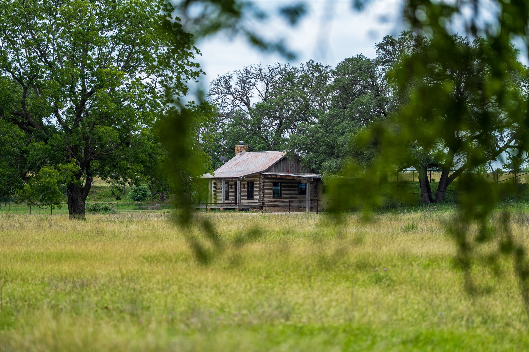 125 Hye Albert Road Hye, TX 78635 - Photo 2 of 39 Rear view of house with a chimney and log siding