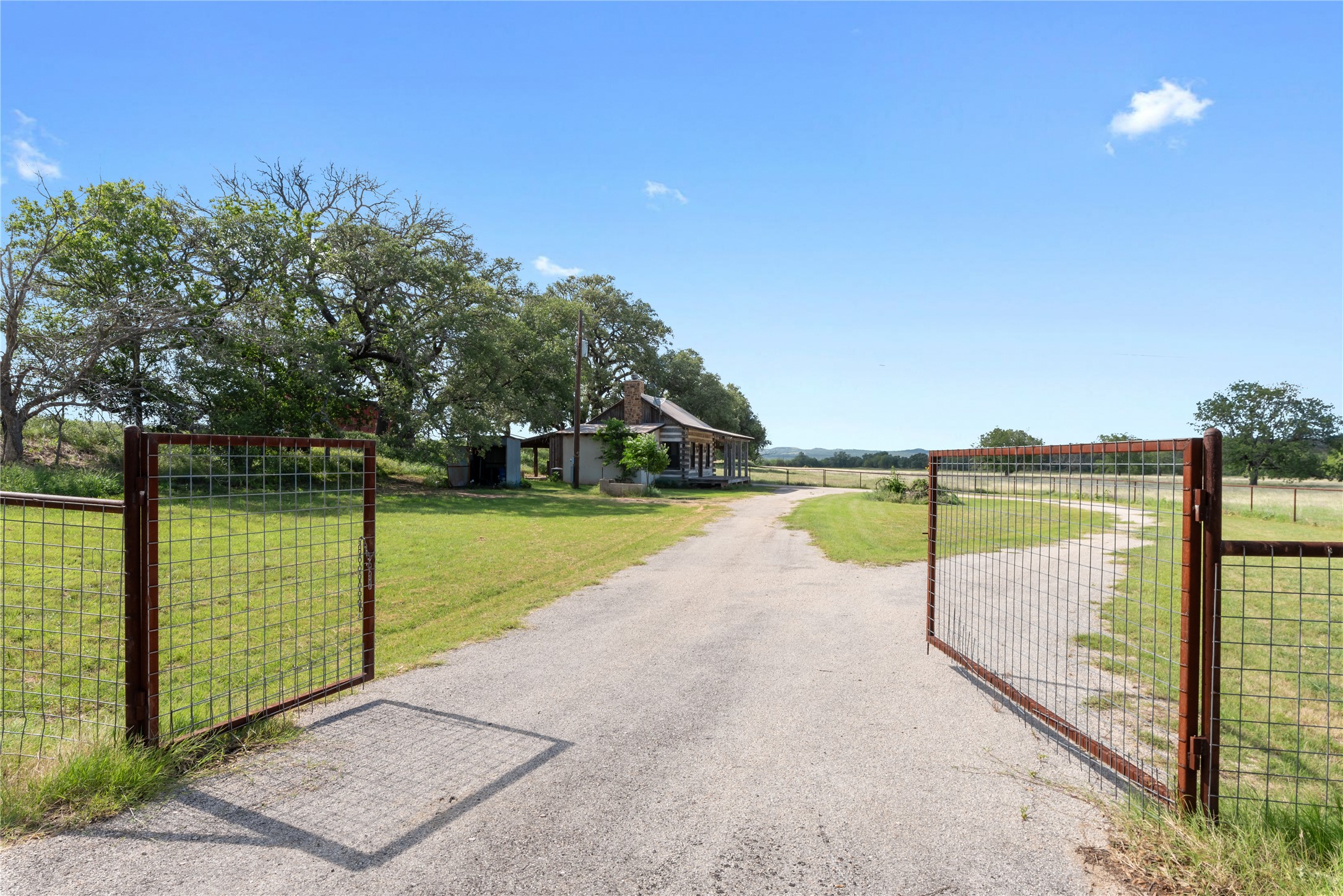 125 Hye Albert Road Hye, TX 78635 - Photo 25 of 39 View of asphalt driveway with a gate, a rural view, and a gated entry