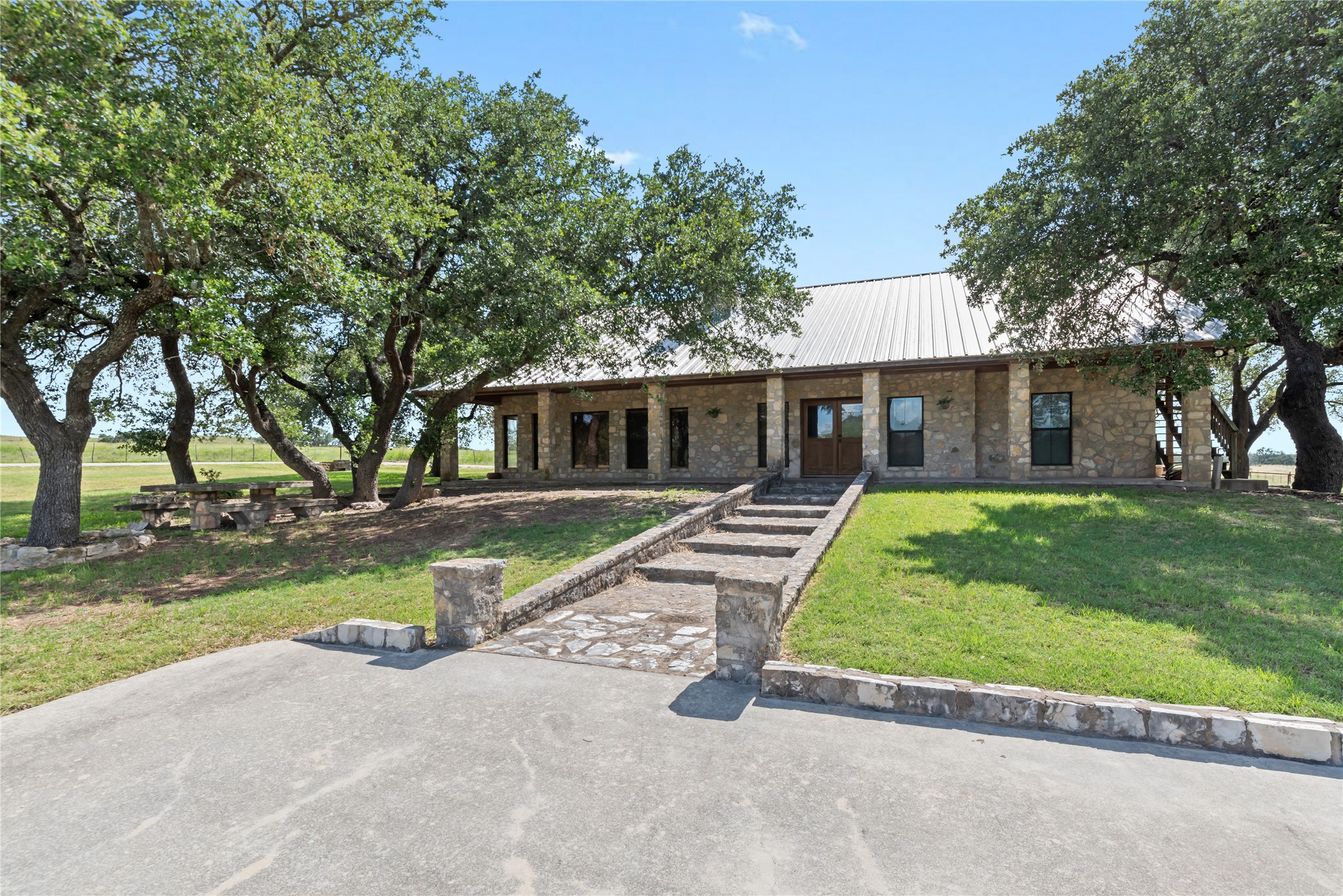 125 Hye Albert Road Hye, TX 78635 - Photo 3 of 39 View of front of house with a front yard, a metal roof, and stone siding