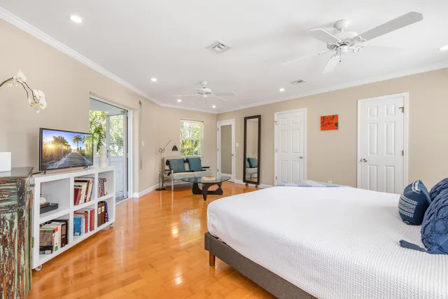a spacious bedroom with a bed a window and a flat screen tv