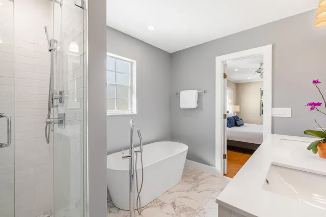 a bathroom with a tub sink and mirror