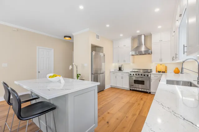 a kitchen with stainless steel appliances a stove a sink cabinets and a refrigerator