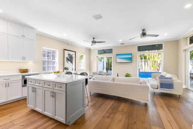 a kitchen that has a lot of cabinets a sink and wooden floor