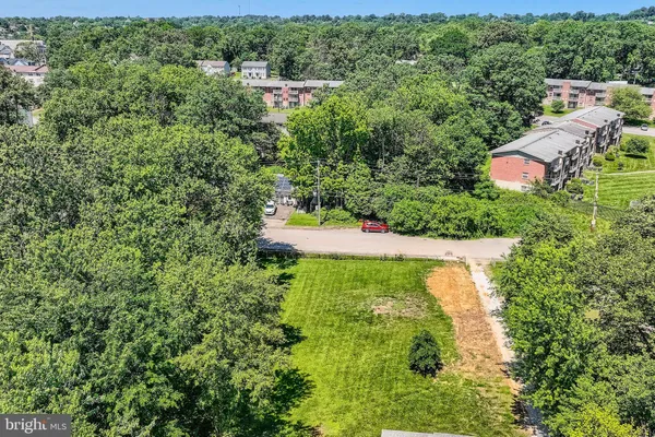 an aerial view of residential house with outdoor space and trees all around
