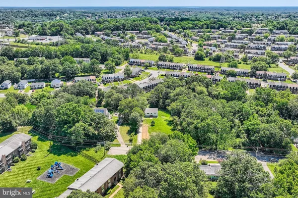 an aerial view of residential houses with outdoor space and trees