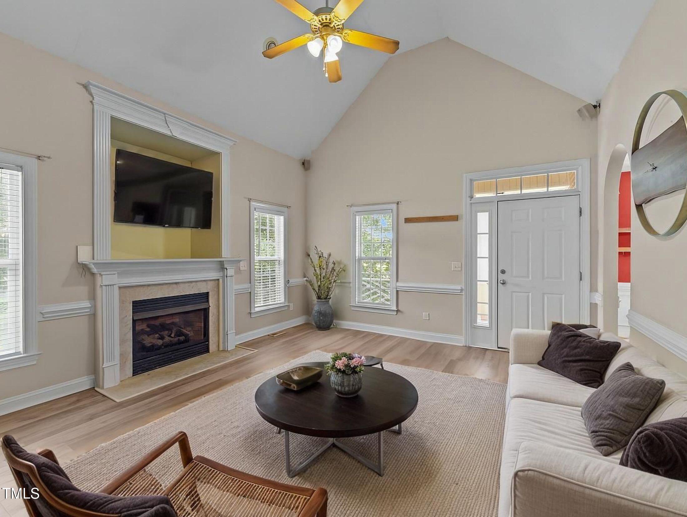 1709 Shell Cracker Drive Willow Spring, NC 27592 - Photo 3 of 28 a living room with furniture a flat screen tv and a fireplace