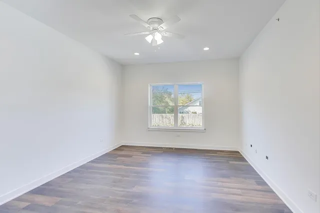 an empty room with wooden floor and window
