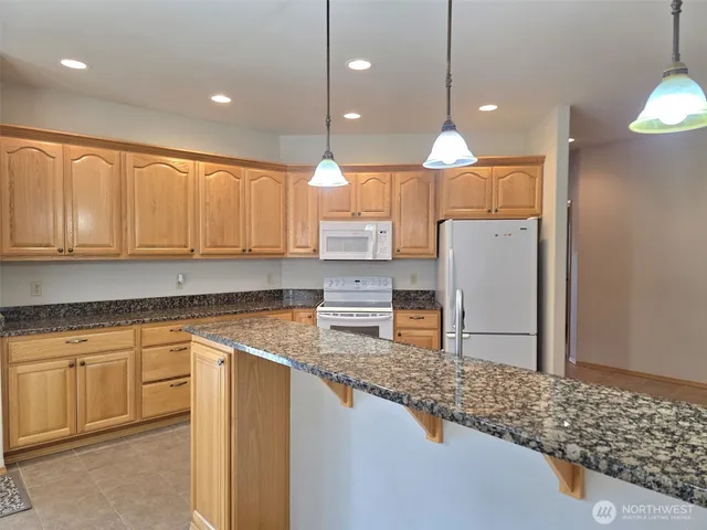 a kitchen with granite countertop a sink and a wooden floor