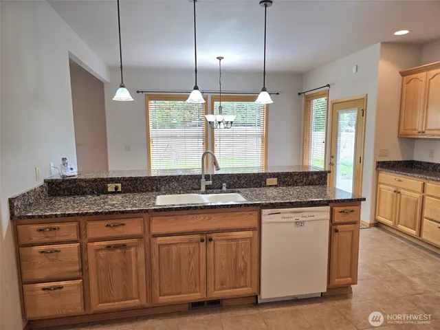 a kitchen with stainless steel appliances granite countertop a sink a stove and a refrigerator