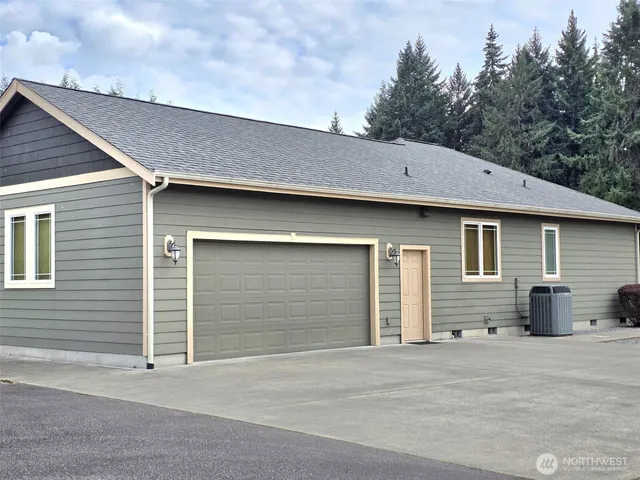 a patio with table and chairs and floor to ceiling window with garden
