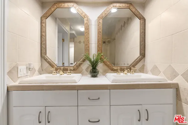 a bathroom with double vanity sinks and a mirror