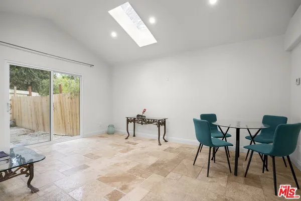 a dining room with furniture and a window