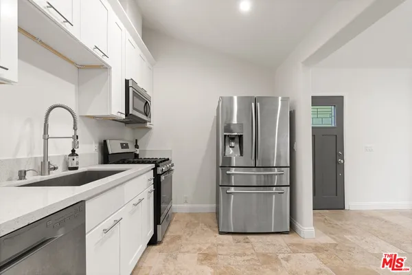 a kitchen with stainless steel appliances granite countertop a refrigerator sink and stove