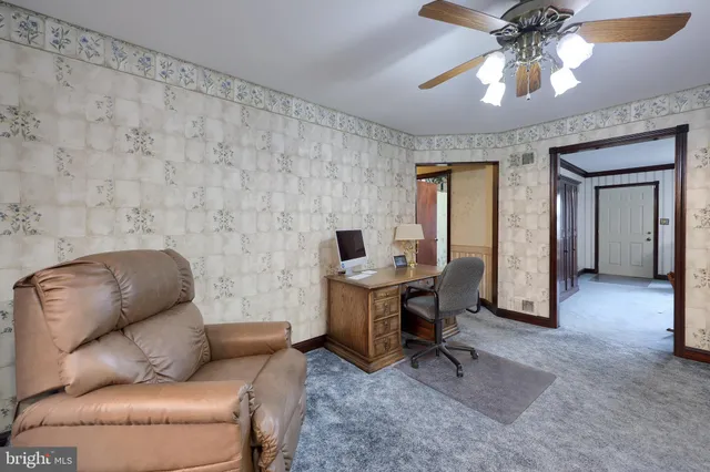 a work room with furniture and a chandelier fan