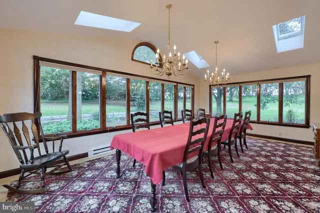 a view of a dining room with furniture large windows and wooden floor